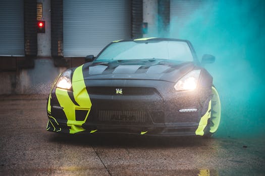 Contemporary sports car with headlights lights and yellow wrapping design parked near wall with closed blinds in green fume from smoke bomb