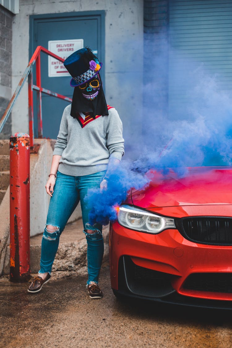 Unrecognizable Woman With Smoke Bomb Near Car