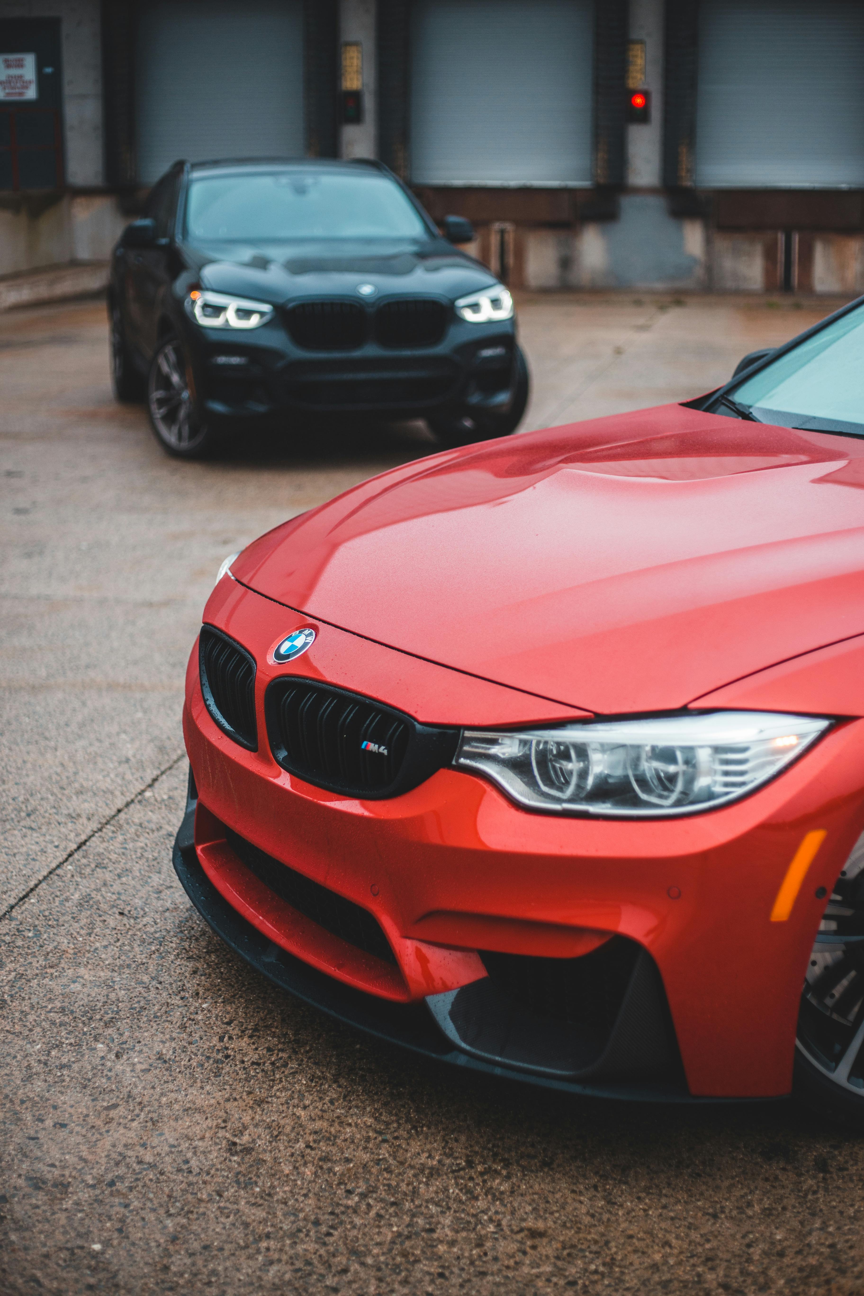 Shiny expensive cars near garage in daylight · Free Stock Photo