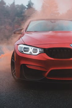 Close-up of a sleek red sports car on a misty road, exuding modern elegance and power.