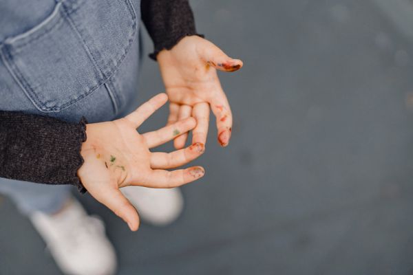 Child's hands covered in colorful paint