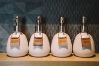 Pump bottles on a wooden shelf — photo by Charlotte May on Pexels