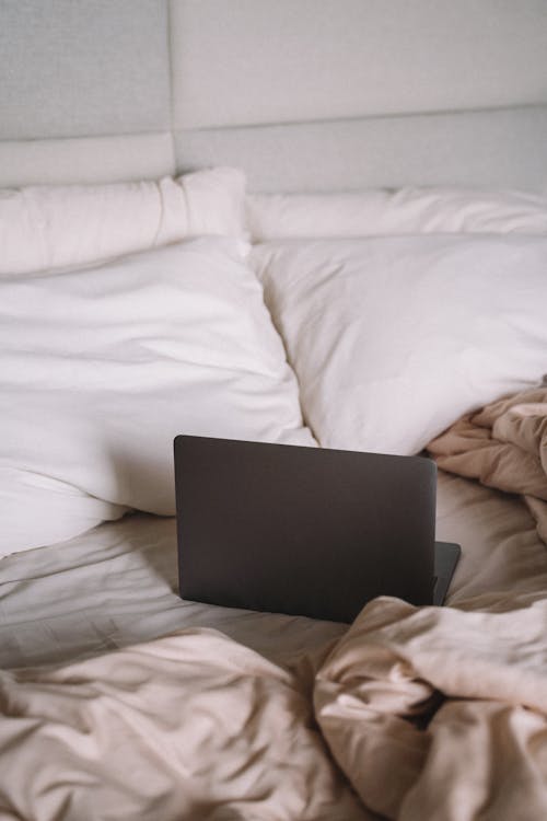 Ücretsiz Beyaz Yatakta Siyah Dizüstü Bilgisayar Stok Fotoğraflar