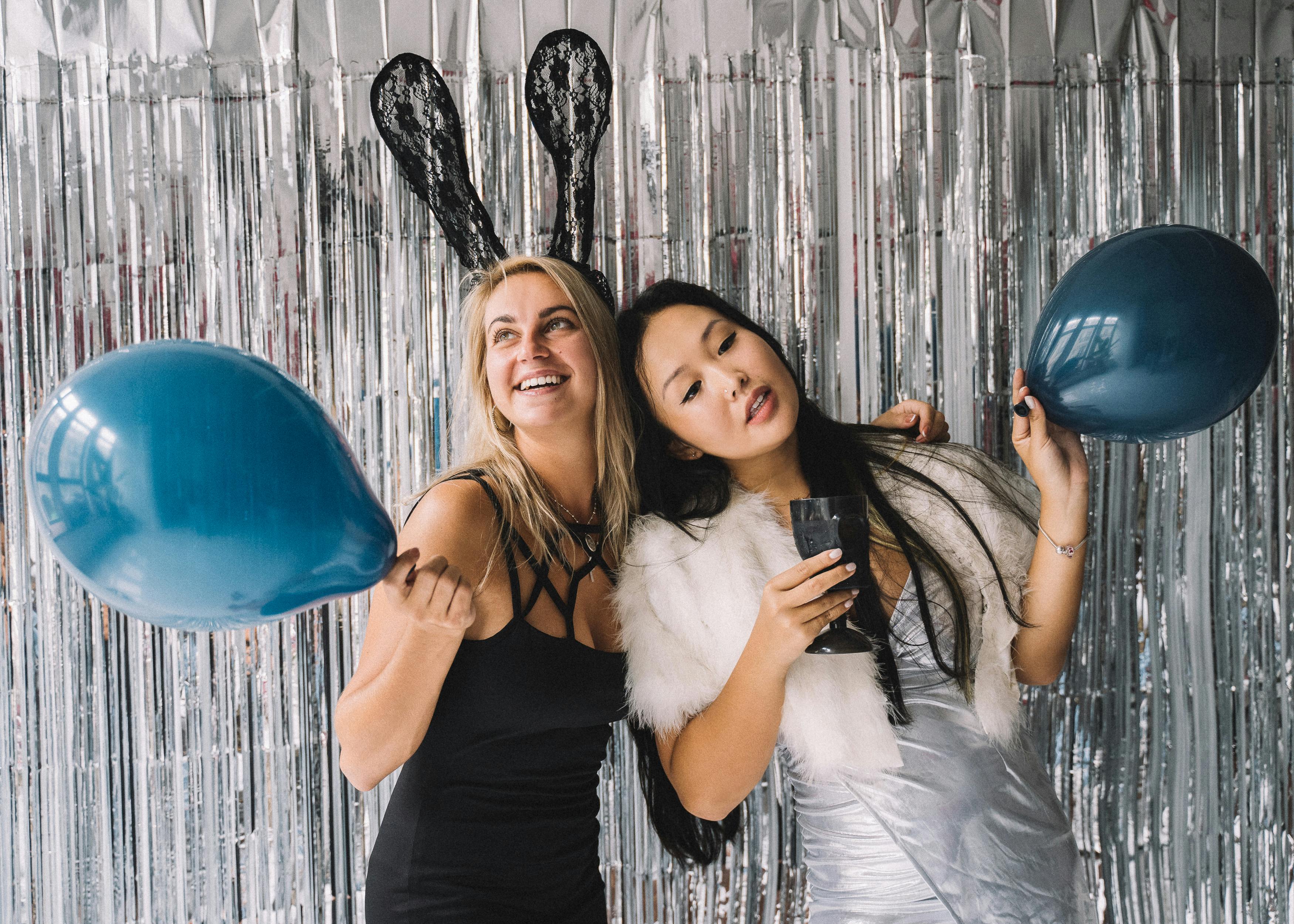 women standing in front of foil curtain