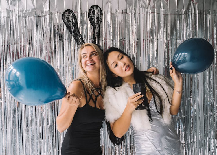 Women Standing In Front Of Foil Curtain