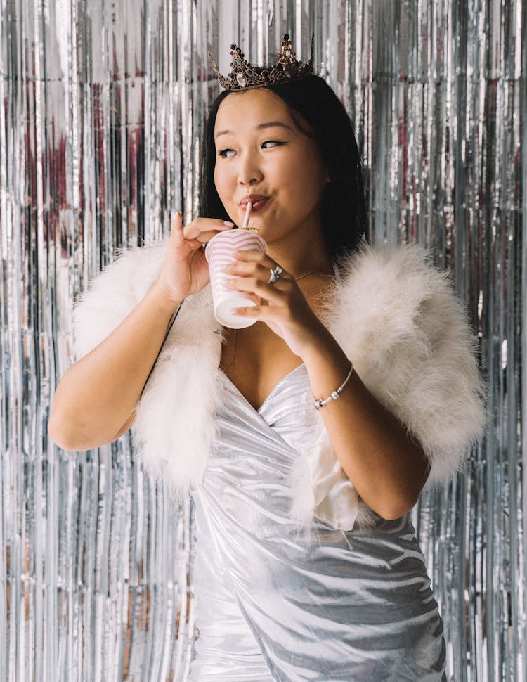 Woman In Silver Dress Drinking From A Straw