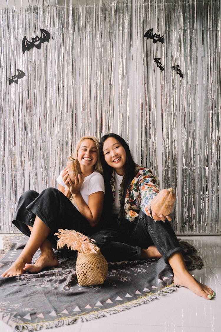 Smiling Women Holding Squashes Together