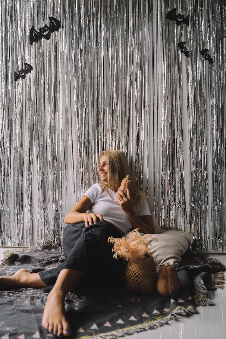 Photo Of A Woman Sitting Near Halloween Decorations