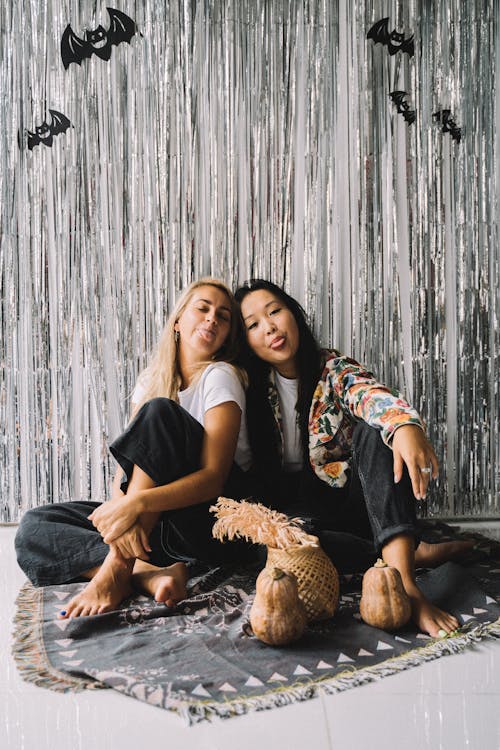 Photo of Women Sitting Near Halloween Decorations