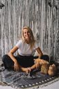 Woman in White Crew Neck T-shirt and Black Denim Jeans Sitting on Black Wooden Bench
