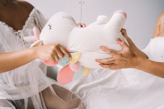 A playful tug-of-war with a colorful unicorn plush toy. Ideal for children's play concepts.