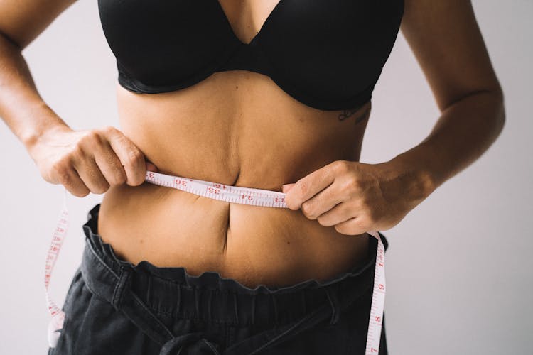 Woman's Hands Measuring Her Waistline