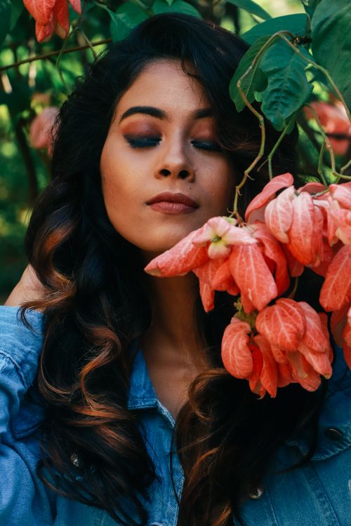 Free A serene portrait of a woman with closed eyes surrounded by vibrant flowers, embracing nature's beauty. Stock Photo