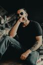 Man in Black Crew Neck T-shirt and Blue Denim Jeans Wearing Black Sunglasses