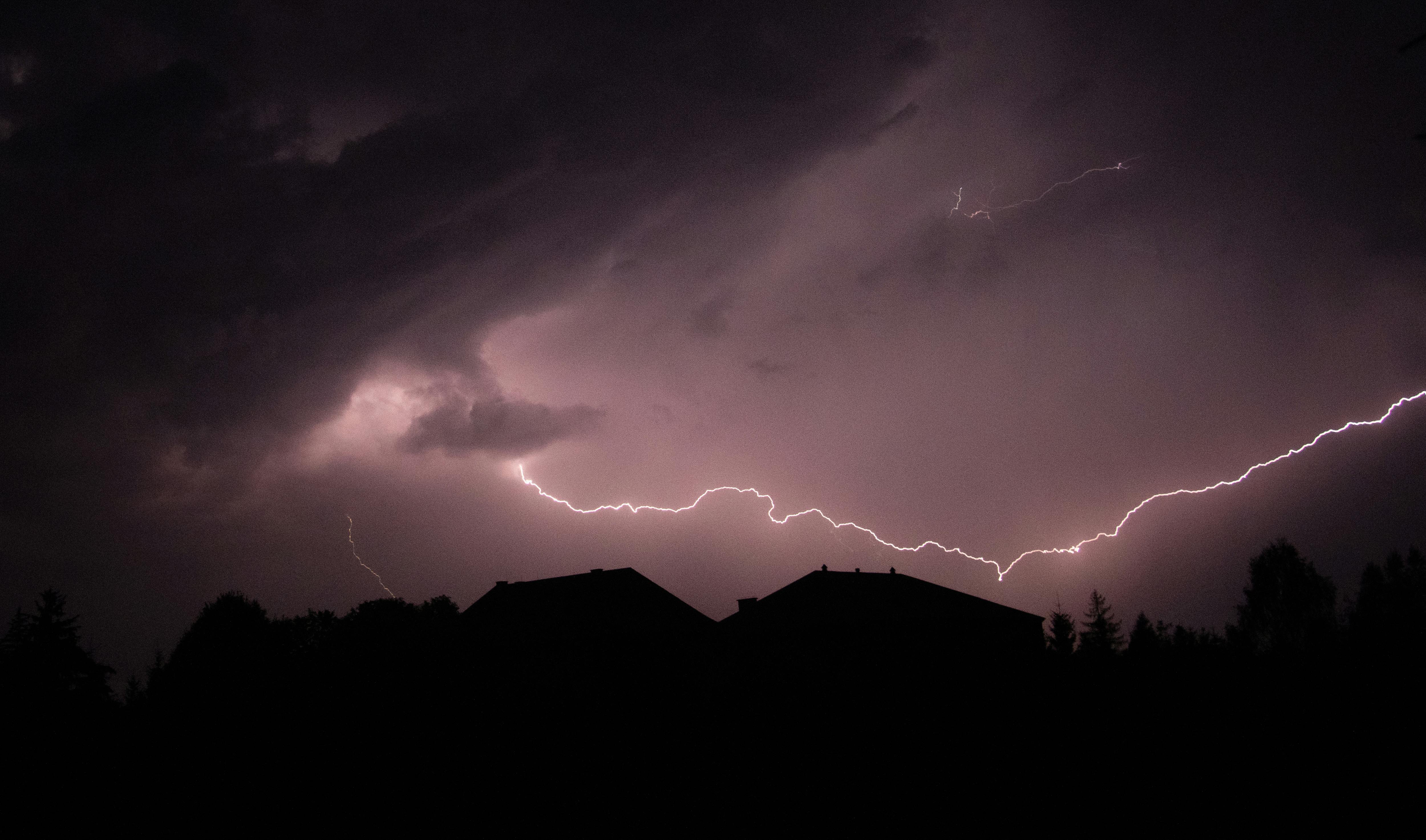 lightning striking above houses