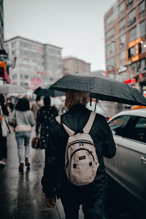 Faceless tourist with umbrella in city