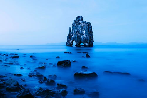 Free Rock Formation in Middle of Body of Water Stock Photo