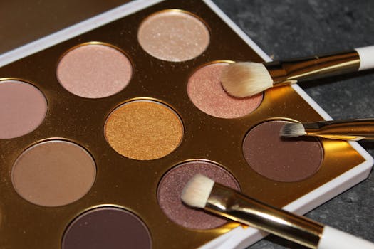 A close-up view of a colorful eyeshadow palette with brushes on a dark surface.