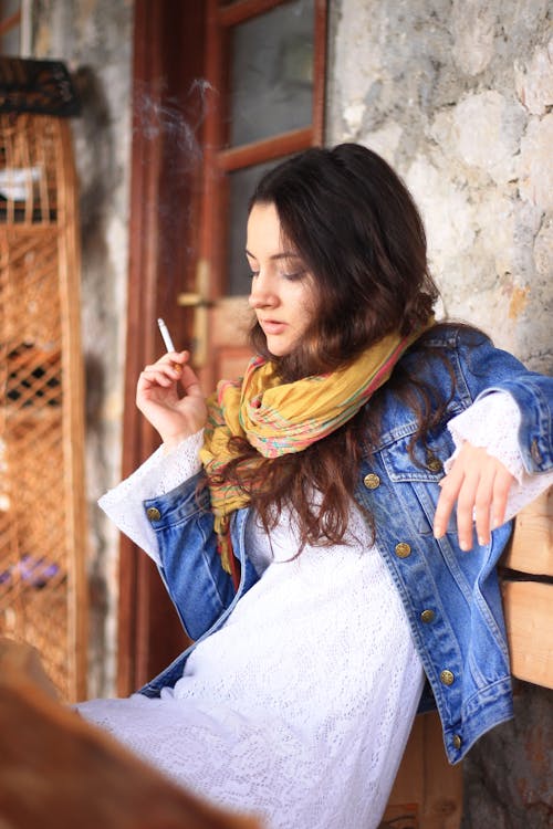 Serious young woman smoking cigarette