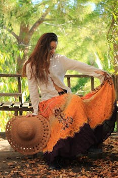 A young woman in a colorful skirt sits gracefully on a park bench, enjoying a sunny day.