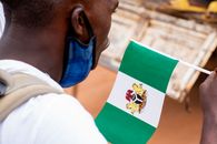 Man in White Long Sleeve Shirt Wearing Blue Goggles Holding Green Flag