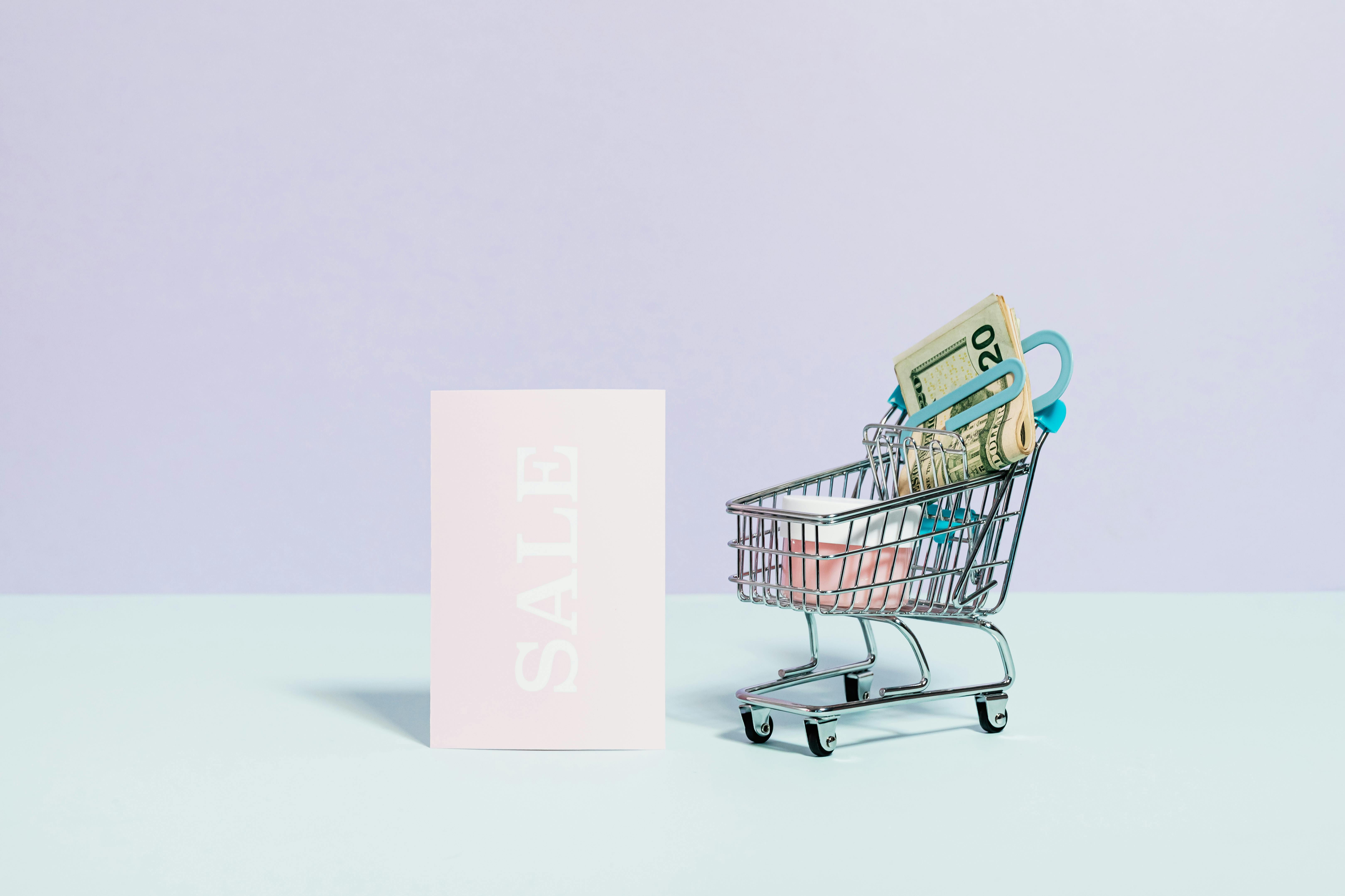 sale sign beside a miniature shopping cart
