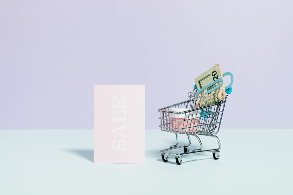 Free Sale Sign Beside A Miniature Shopping Cart Stock Photo