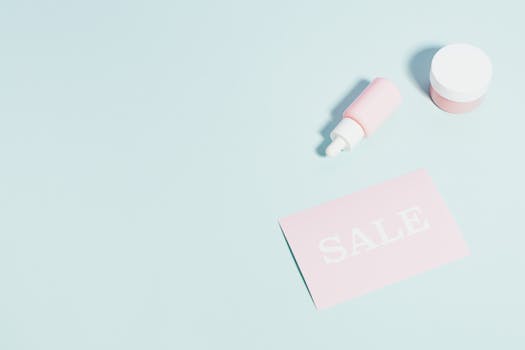 粉红色美容产品和销售标志位于粉彩背景上