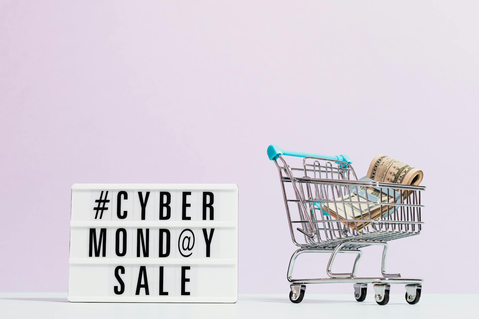 TCas Money On A Shopping Cart Beside A Cyber Monday Sale Signext