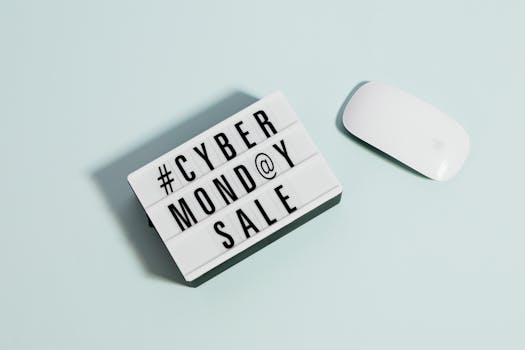 Lightbox sign displaying 'Cyber Monday Sale' beside a computer mouse on a pastel background.