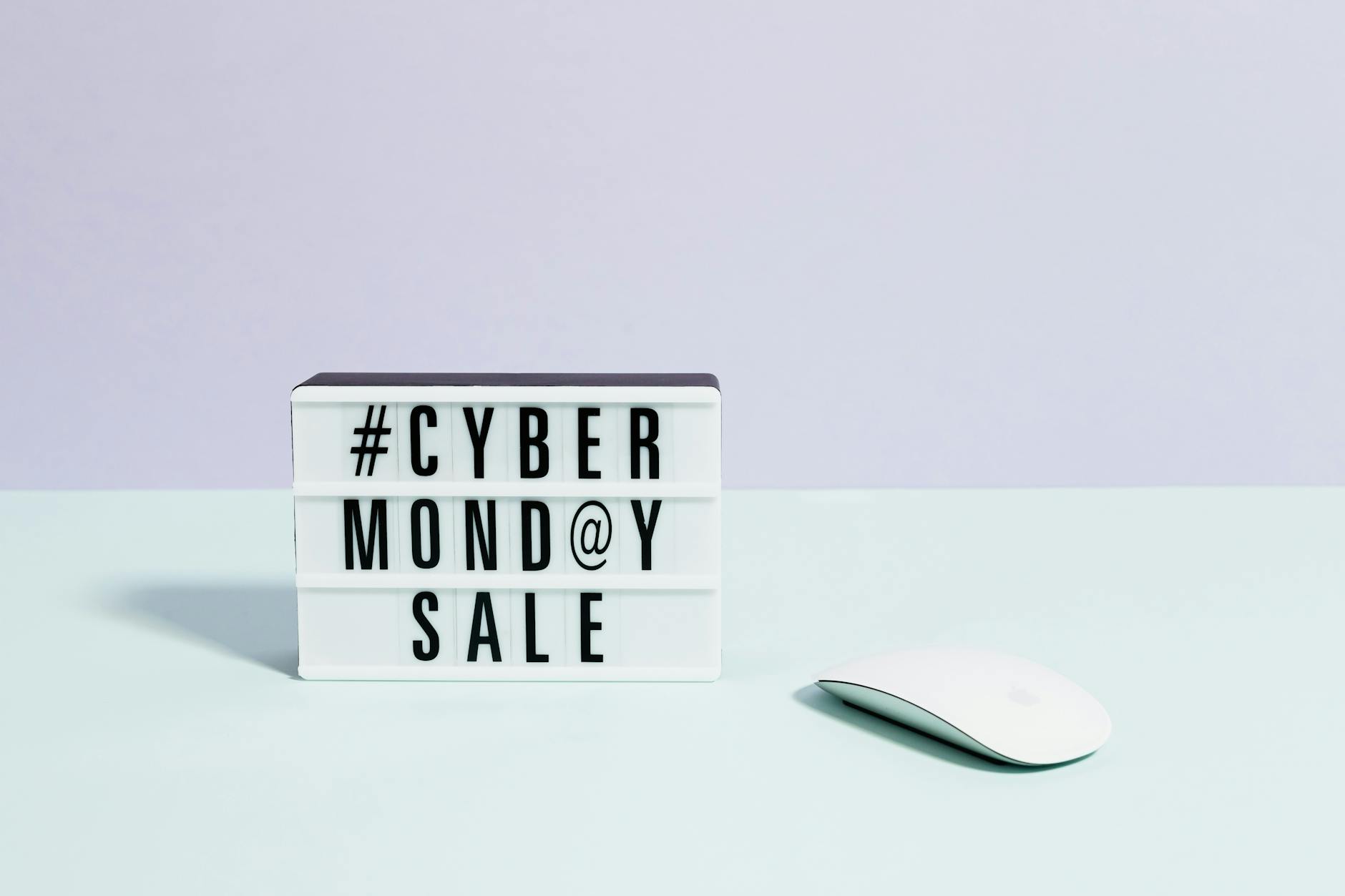 Minimalist setup featuring a Cyber Monday sale sign and computer mouse, perfect for online shopping themes.