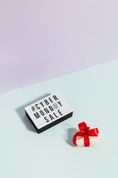 Minimalist setup showing a Cyber Monday sale sign and a gift box with a red bow.