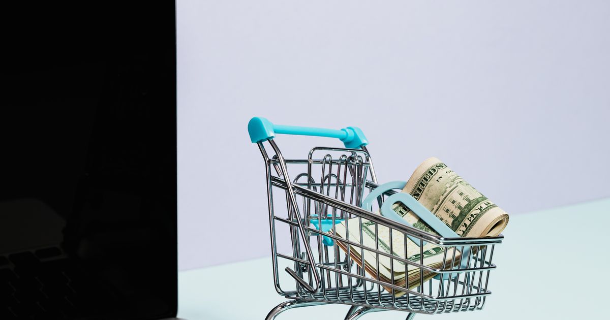 Shopping cart with money on a laptop