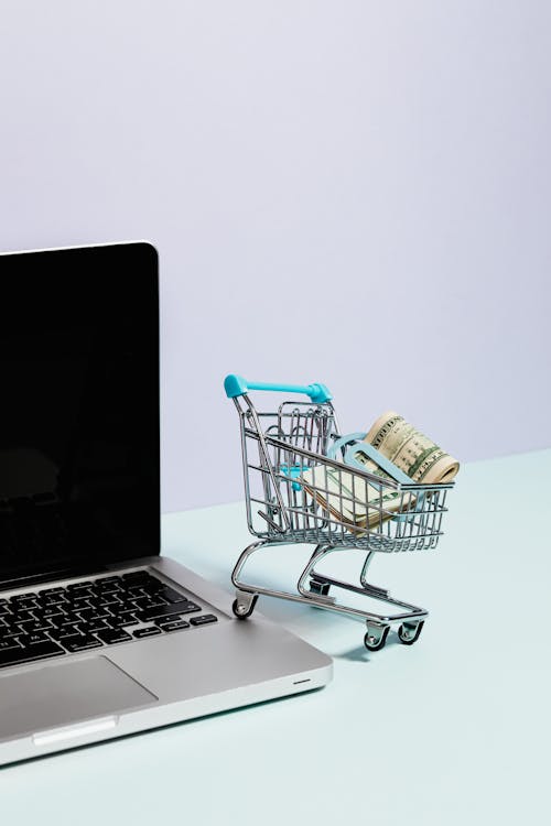 Free Shopping Cart with Money on Top of a Laptop Stock Photo