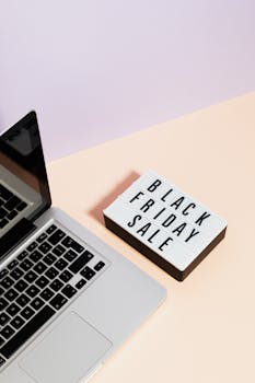 Minimalist laptop scene with black friday sale sign, perfect for retail marketing visuals.