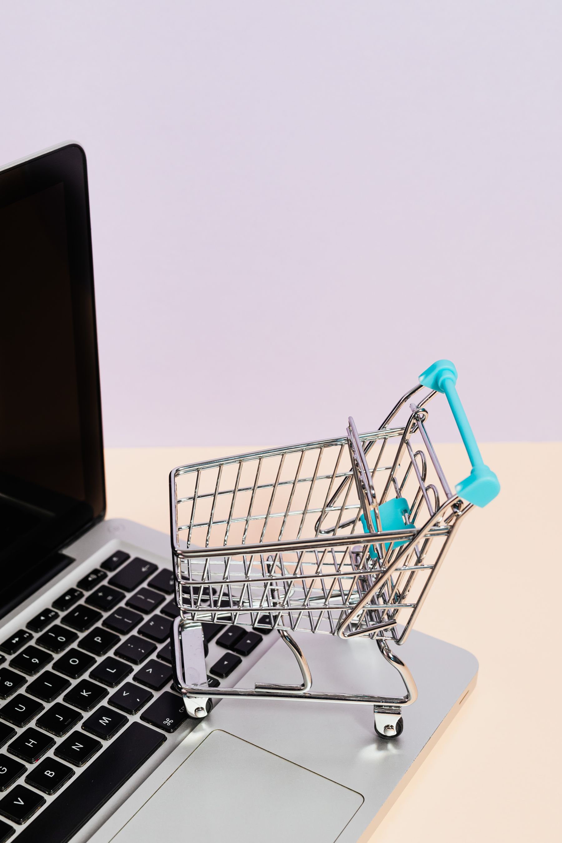 Carrito de la compra en miniatura sobre el teclado de un portátil