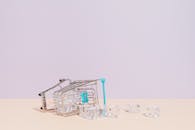 Ice Cubes Spilling From Tipped Over Miniature Shopping Cart