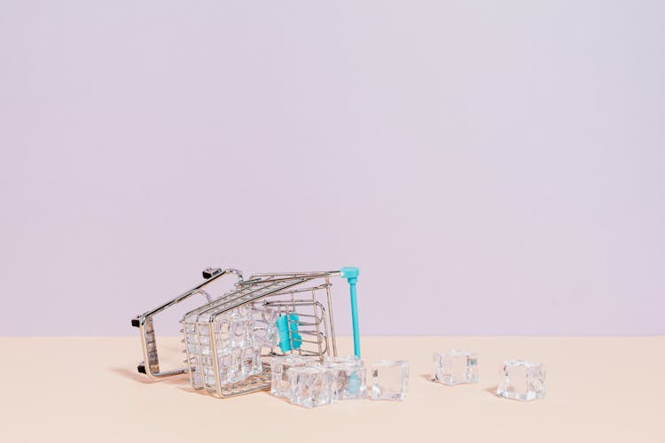 Ice Cubes Spilling From Tipped Over Miniature Shopping Cart