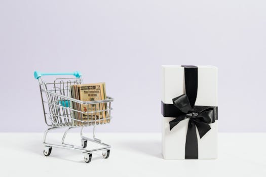 Shopping cart filled with dollar bills next to a black ribbon gift box, symbolizing commerce and presents.