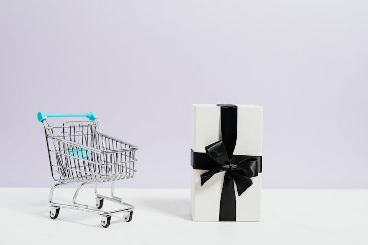 Shopping Cart Next To A Gift Box