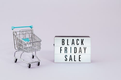 Shopping Cart Next to a Black Friday Sale Sign