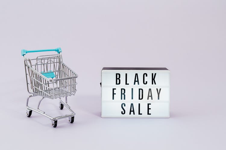 Shopping Cart Next To A Black Friday Sale Sign