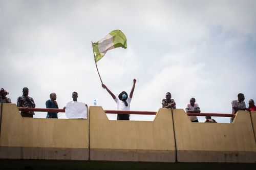 Free Protesters on bridge wave Nigerian flag, showcasing unity and activism. Stock Photo