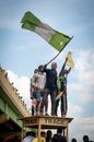 Man in Gray Jacket Holding Green Flag