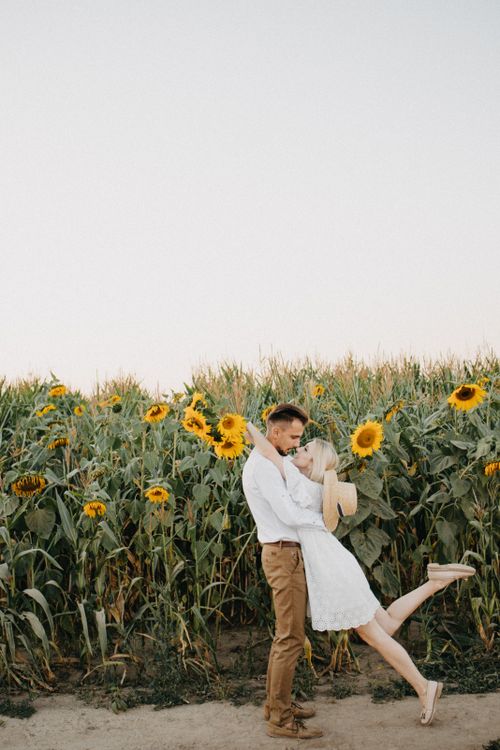 Free Couple in love sharing a tender moment in a beautiful sunflower field, capturing a sense of romance and nature. Stock Photo