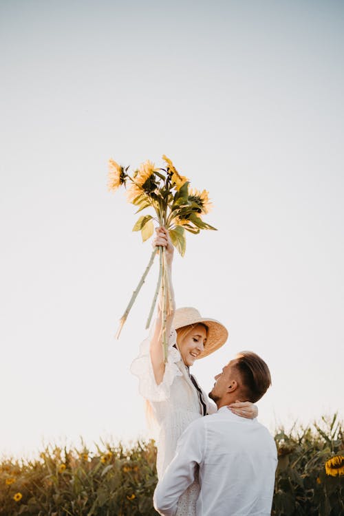 Woman in White Dress Holding Yellow Sunflower Bouquet