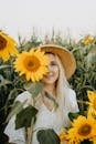 Woman in White Long Sleeve Shirt Holding Sunflower