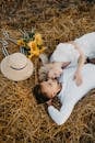 Man in White Shirt Kissing Woman in White Dress on Brown Grass Field