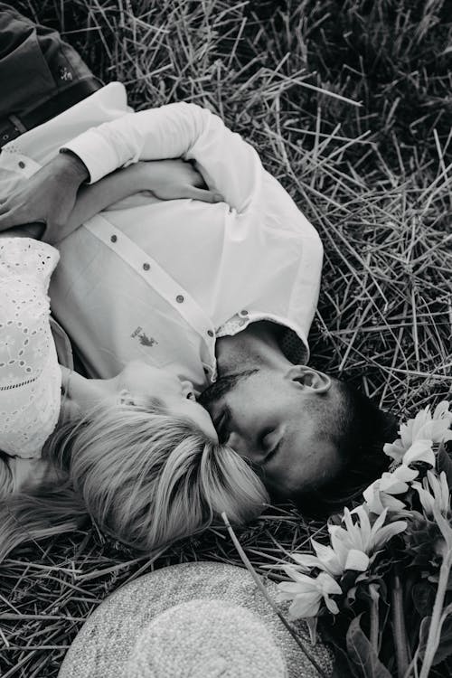 Grayscale Photo of a Couple Lying Down