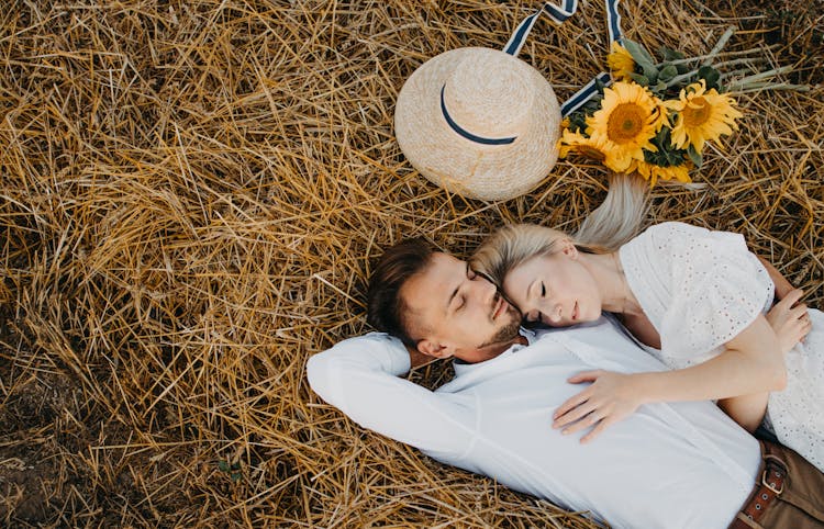 Couple Lying Down On A Field